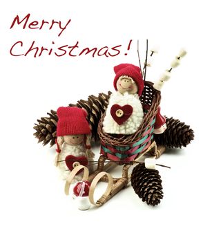Christmas Decoration Concept with Handmade Dolls in Knit Hats, Fir Cones, Sleigh and Marshmallows on Wooden Sticks with Inscription closeup on White background