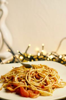 Italian tasty pasta with tomatoes on a fork. Christmas food concept.