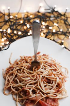 Italian tasty pasta with tomatoes on a fork. Christmas food concept.