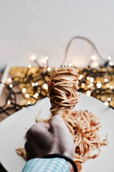 Italian tasty pasta with tomatoes on a fork. Christmas food concept.
