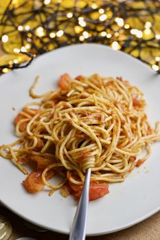 Italian tasty pasta with tomatoes on a fork. Christmas food concept.