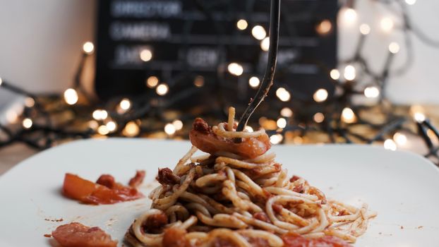 Italian tasty pasta with tomatoes on a silver fork. Christmas concept.