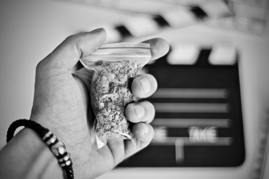 Green dry marijuana in man hand on the blurry background. Weed concept.
