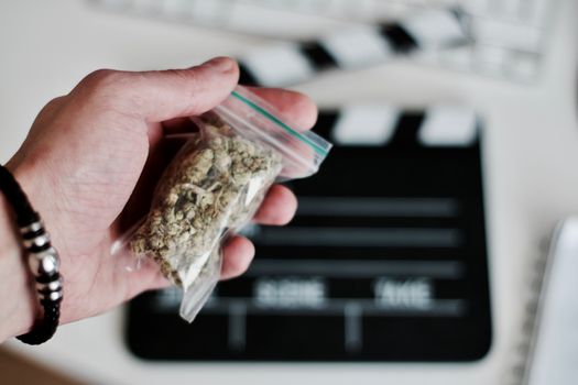 Green dry marijuana in man hand on the blurry background. Weed concept.