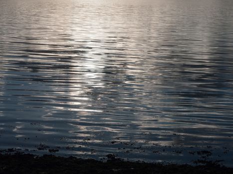 beautiful water surface sunset light waves ripples light; essex; england; uk