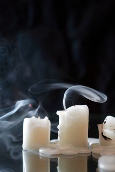 Set of extinguished candles with smoke on nice dark background