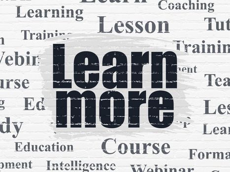Learning concept: Painted black text Learn More on White Brick wall background with  Tag Cloud