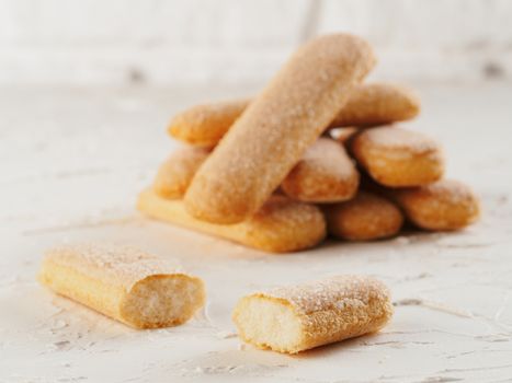 Close up view of ladyfinger biscuit cookie on white concrete background. Italian cookie savoiardi.