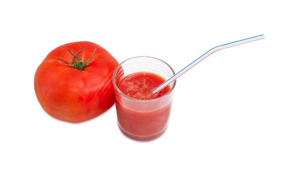 One fresh ripe tomato and tomato juice in glass with bendable drinking straw on a light background
