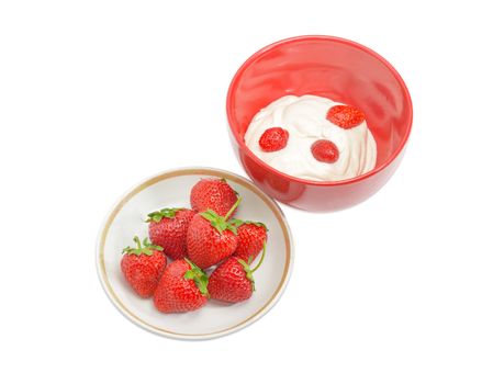 Fresh berries of the strawberry on the saucer and in the red ceramic bowl with whipped cream  on a light background
