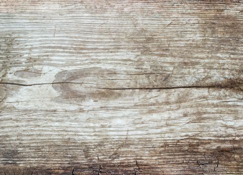 Background of a surface of the old dilapidated wooden plank covered by cracks and darkened with time
