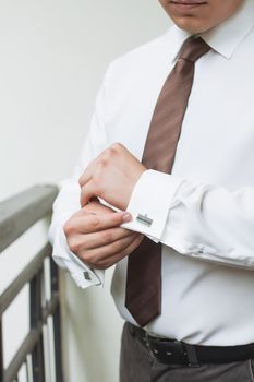 man buttons shirt, a man in a white shirt, morning groom, hands of a man close-up, a white shirt on a businessman, man buttons shirt sleeve, businessman puts on a suit