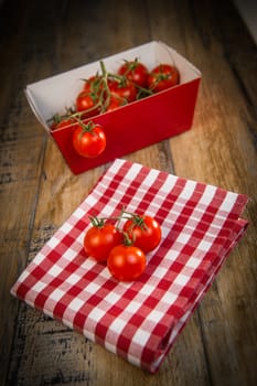 Fresh cherry tomatoes on travel and wooden background, France