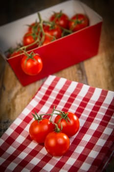 Fresh cherry tomatoes on travel and wooden background, France