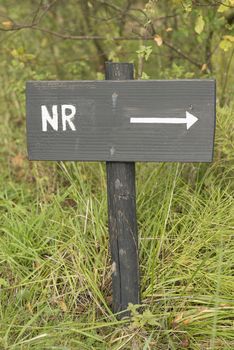 Grey wooden sign with the abbreviated Dutch text number in white color
