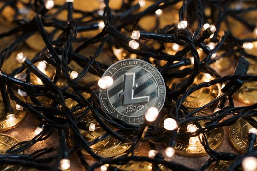 Digital currency physical metal Litecoin coin on the christmas lights concept.