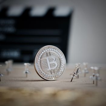 Digital currency physical metal bitcoin coin. Cryptocurrency cinema concept.