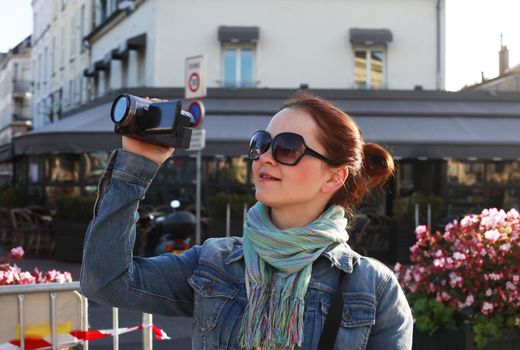 Girl using camcorder in the street Paris
