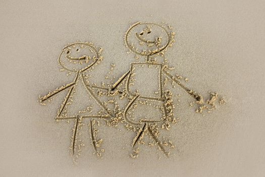 The child has drawn mum and daddy on sand