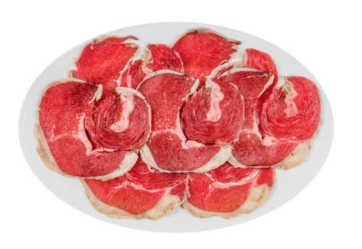 Top view of some raw beef fillets on a plate with  white background