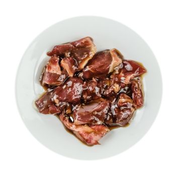 Top view of some raw beef fillets on a plate with  white background