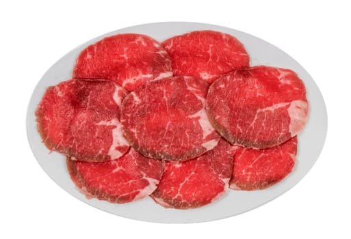 Top view of some raw beef fillets on a plate with  white background