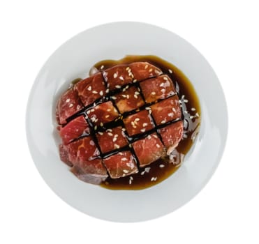 Top view of some raw beef fillets on a plate with  white background