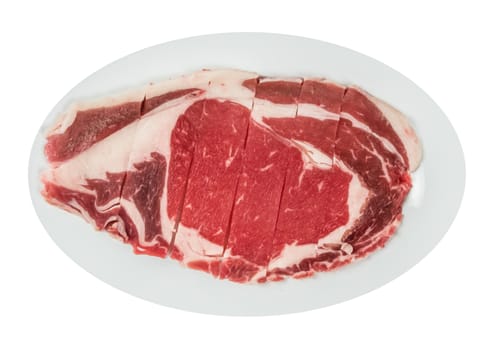 Top view of some raw beef fillets on a plate with  white background