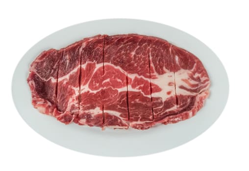 Top view of some raw beef fillets on a plate with  white background