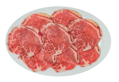 Top view of some raw beef fillets on a plate with  white background