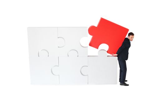 Business pushing the final piece of puzzle isolated on white