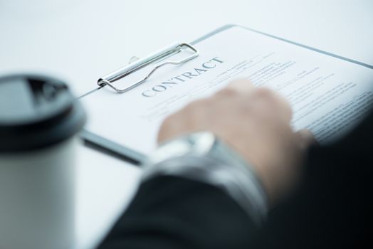 Businessman signing a contract close up view from behind