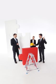 Business team assembling big puzzle isolated on white background