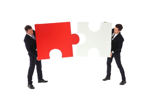 Business men holding two puzzle pieces to connect isolated on white background