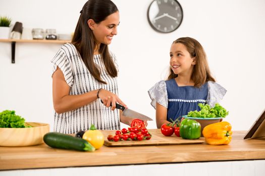 Shot of a mother and daughter having fun in the kitchen