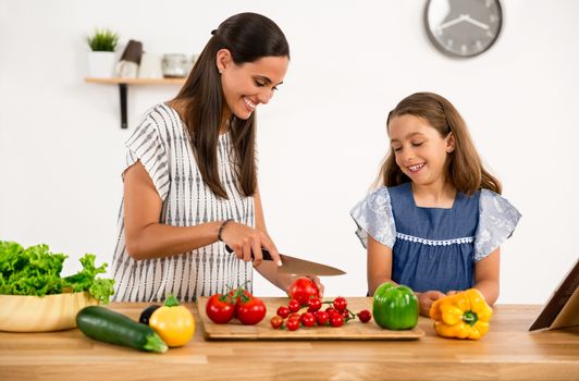 Shot of a mother and daughter having fun in the kitchen