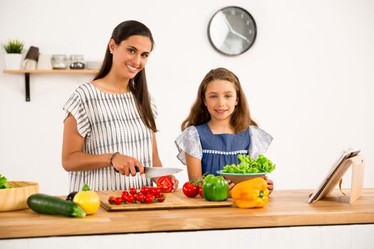 Shot of a mother and daughter having fun in the kitchen