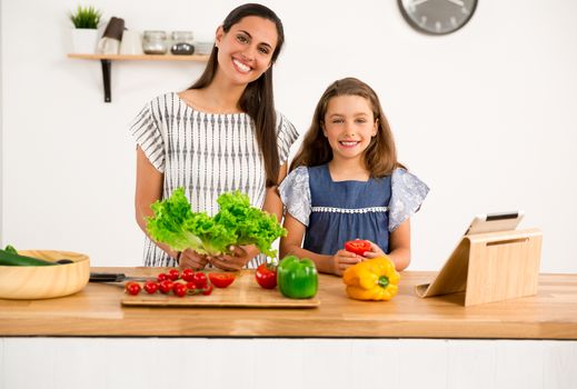 Shot of a mother and daughter having fun in the kitchen