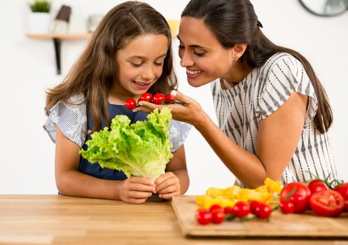 Shot of a mother and daughter having fun in the kitchen