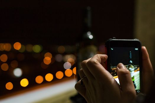 phone in the hands of the wine lights night instagram