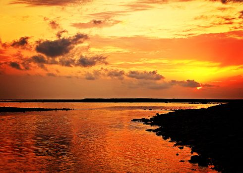 Crimson beautiful sunset summer sun on the sea coast.