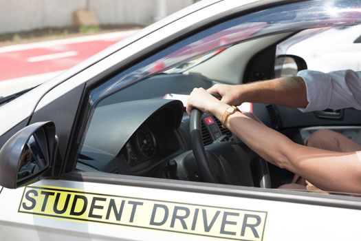 Learner driver student driving car with instructor