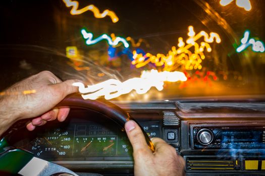 the driver in the car the first face of the road the lights of the night city