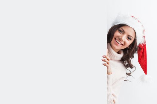 Woman in Santa hat with blank banner with white copyspace