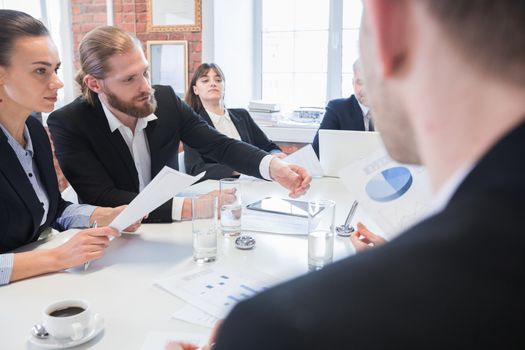 Meeting of business partners talking at the table discussing diagrams