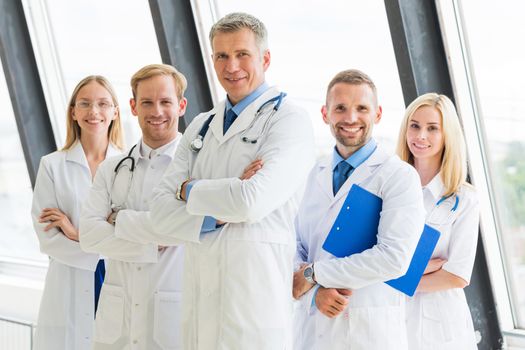 Successful team of medical doctors are looking at camera and showing thumbs up