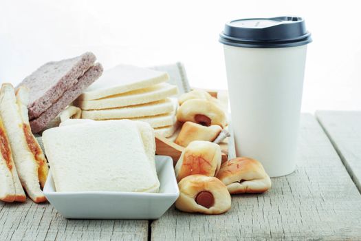 Bread and coffee cup on a wooden table.