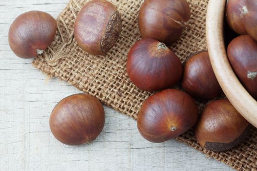 Roasted chestnuts on a sack with top view.