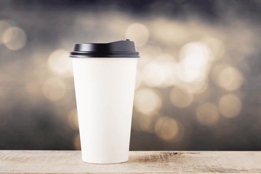 Coffee cup paper on wooden with bokeh background.