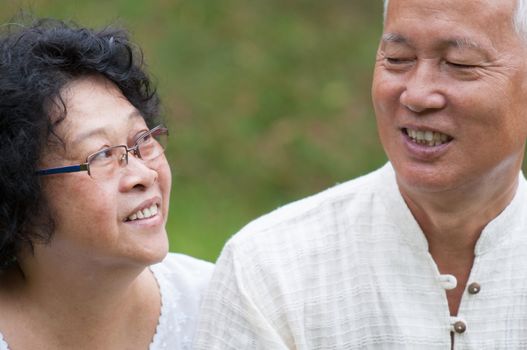 Happy Asian old couple relaxing at outdoor park on a summer day.